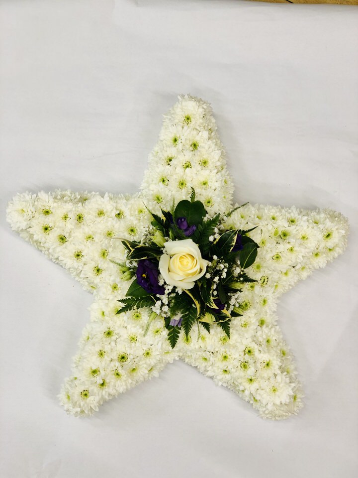 <h2>Bespoke 5 Point Star Tribute | Funeral Flowers</h2>
<ul>
<li>Approximate Size 30 x 30cm</li>
<li>Hand created white star in fresh flowers</li>
<li>To give you the best we may occasionally need to make substitutes</li>
<li>Funeral Flowers will be delivered at least 2 hours before the funeral</li>
<li>For delivery area coverage see below</li>
</ul>
<br>
<h2>Liverpool Flower Delivery</h2>
<p>We have a wide selection of Bespoke Funeral Tributes offered for Liverpool Flower Delivery. Bespoke Funeral Tributes can be provided for you in Liverpool, Merseyside and we can organize Funeral flower deliveries for you nationwide. Funeral Flowers can be delivered to the Funeral directors or a house address. They can not be delivered to the crematorium or the church.</p>
<br>
<h2>Flower Delivery Coverage</h2>
<p>Our shop delivers funeral flowers to the following Liverpool postcodes L1 L2 L3 L4 L5 L6 L7 L8 L11 L12 L13 L14 L15 L16 L17 L18 L19 L24 L25 L26 L27 L36 L70 If your order is for an area outside of these we can organise delivery for you through our network of florists. We will ask them to make as close as possible to the image but because of the difference in stock and sundry items it may not be exact.</p>
<br>
<h2>Liverpool Funeral Flowers | Bespoke Tributes</h2>
<p>This 5 point star-shaped funeral design has been loving handcrafted by our expert florists. It features a mass of white spray chrysanthemums together with a cluster of beautiful flowers in the middle making this a star to remember.</p>
<br>
<p>Bespoke Funeral Tributes are a way to create a tribute that is truly unique and specially designed for a loved one.</p>
<br>
<p>These are sometimes selected by family members as the main tribute or more often a group of friends or workplace colleagues as a symbol of things they associate with the deceased.</p>
<br>
<p>The flowers are arranged in floral foam, which means the flowers have a water source so they look their very best for the day.</p>
<br>
<p>Contains 20 white spray chrysanthemums together with a spray of seasonal flowers, which we can do in any colour. This example shows a white rose, purple lisianthus and gypsophila.</p>
<br>
<h2>Best Florist in Liverpool</h2>
<p>Trust Award-winning Liverpool Florist, Booker Flowers and Gifts, to deliver funeral flowers fitting for the occasion delivered in Liverpool, Merseyside and beyond. Our funeral flowers are handcrafted by our team of professional fully qualified who not only lovingly hand make our designs but hand-deliver them, ensuring all our customers are delighted with their flowers. Booker Flowers and Gifts your local Liverpool Flower shop.</p>
<br>
<p><em>Debera G - 5 Star Review on yell.com - Funeral Florist Liverpool</em></p>
<br>
<p><em>Fleur and her team made the flowers for my Dad's funeral. I knew I wanted something quite specific but was quite unsure how to execute the idea. Fleur understood immediately what I was hoping to achieve and developed the ideas into amazingly beautiful flowers that were just perfect. I honestly can't recommend her highly enough - she created something outstanding and unique for my Dad. Thanks Fleur.</em></p>
